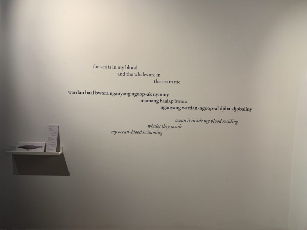 Photo of a haiku installed in vinyl letters on a white gallery wall